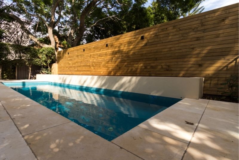A wooden deck surrounding a pool